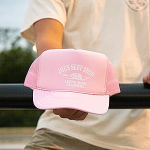 man holding a pink trucker hat