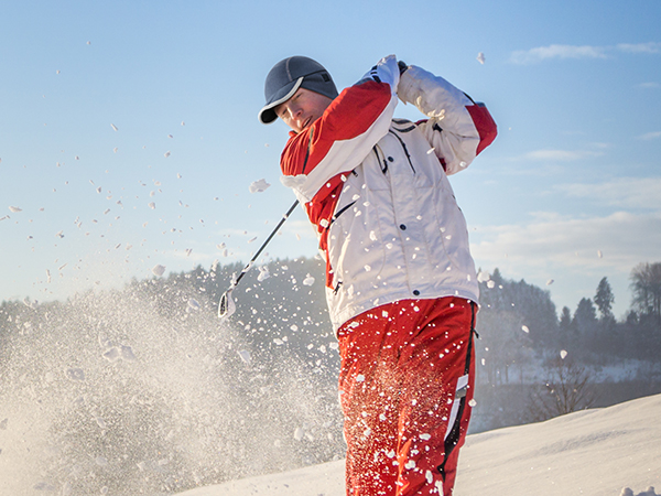 Man with our blue fleece warm hat is golfing at outdoor in winter cold weather